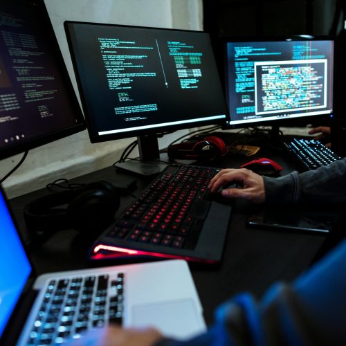 Several people with computers and code on computer